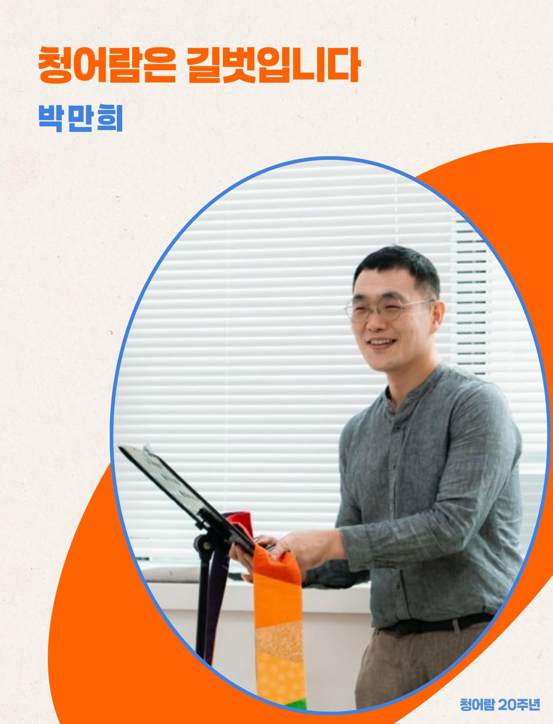 박만희가 보면대 앞에 서 있다. 보면대에는 무지개 스톨이 걸려 있다.