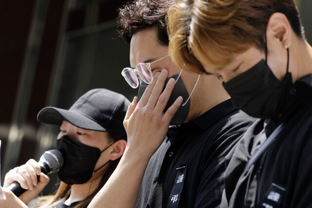 택배노동자 과로사 대책위원회 회원들과 유족들이 21일 오전 서울 중구 서소문동 씨제이(CJ)대한통운 본사 앞에서 지난 14일 과로로 사망한 씨제이(CJ)대한통운 소속 택배노동자 전아무개(48)씨에 대한 대한통운의 사과와 재발방지 대책을 요구하는 기자회견을 열었다. 전씨의 아내(왼쪽)가 발언을 하는 동안 유족이 눈물을 닦고 있다. 김명진 기자 littleprince@hani.co.kr