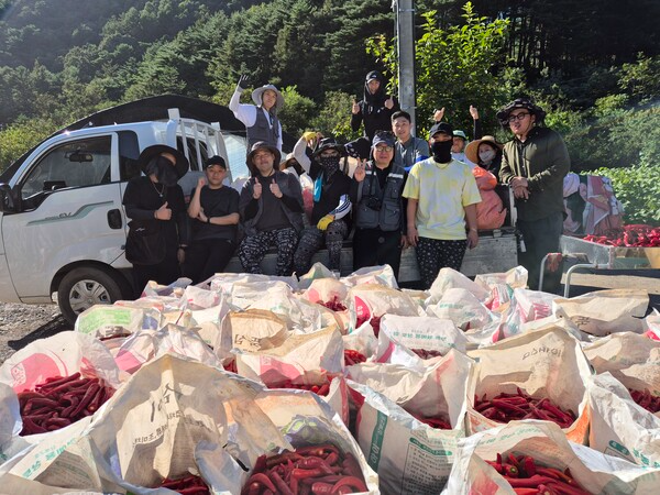 지난해 9월, HR그룹(주) 봉사자들이 평창에서 고추 수확 봉사를 마친 뒤, 수확한 빨간 고추 자루 앞에서 기념사진을 촬영하고 있다./사진=HR그룹(주) 미디어팀 제공