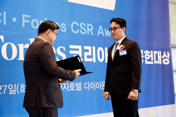 HR그룹 신호룡 대표(오른쪽)가 조영준 대한상공회의소 지속가능경영원장으로부터 ‘2025 포브스 사회공헌대상’ 사회공익 부문 상을 수여받고 있다./사진=HR그룹 미디어팀 제공
