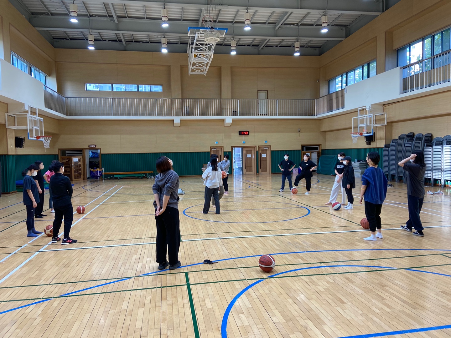 강당에서 큰 원을 만들어 선 채 서로 농구공을 주고 받는다.
