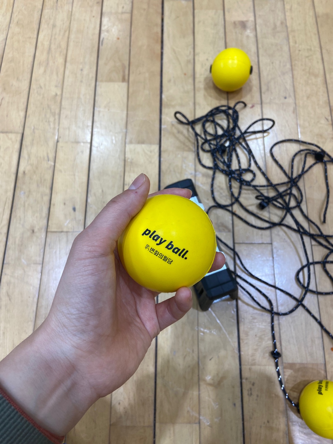 한 손으로 작은 노란색 공을 쥐고 있다.