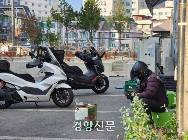 배달노동자들이 2022년 12월 쌍문동의 한 마트 물류창고에서 다음 주문이 올 때까지 대기하고 있다. 강은 기자
