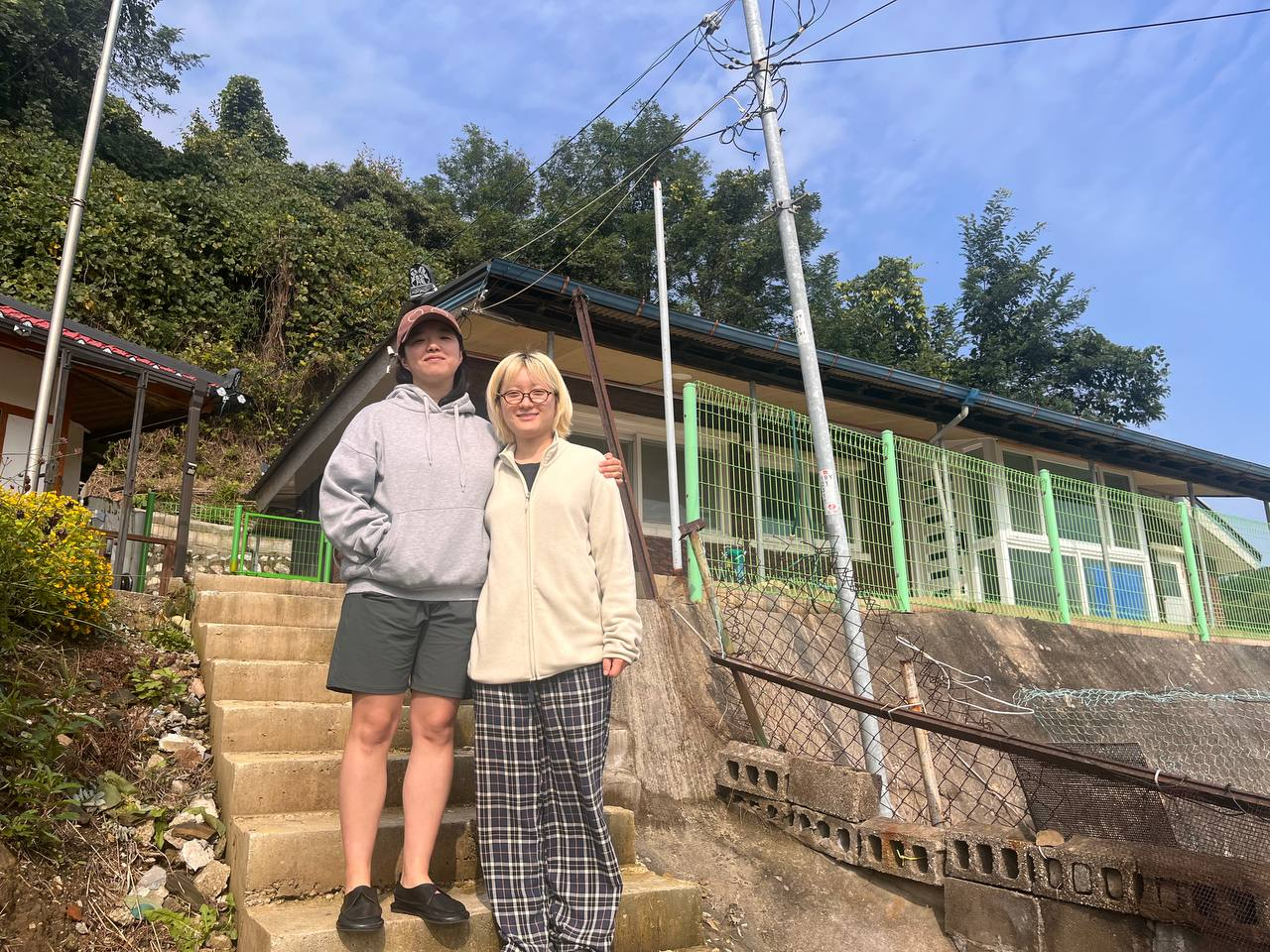 새로 이사한 공간 앞에서 나란히 서 있는 은빈과 수아