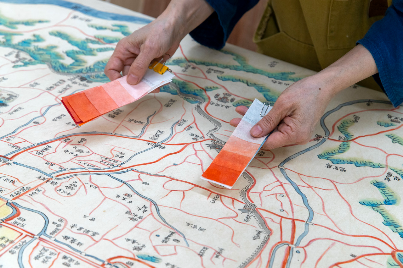 붉은 도로의 색을 맞추기 위해 무기안료인 주사를 농도별로 채색해놓은 색표로 비교해보고 있다. 주사는 붉은색의 무기안료로 종이에 완전히 스며들지 않고 위에 얹혀지는 형식이다. 각 색상의 채색표는 안료의 농도에 따라 단계별로 만들어졌다. ⓒ시사IN 박미소