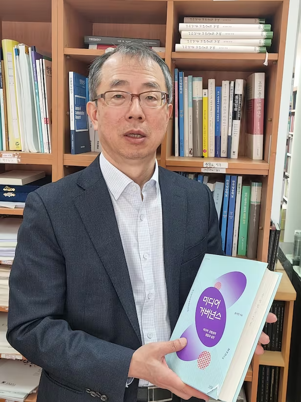 윤석민 교수가 2020년 출간한 저서 <미디어 거버넌스>를 들여 보이고 있다. 참고문헌을 포함해 900쪽이 넘는 대작이다. 그는 "책 자료 조사와 집필에 6년 여 걸렸다"고 말했다./송의달 기자