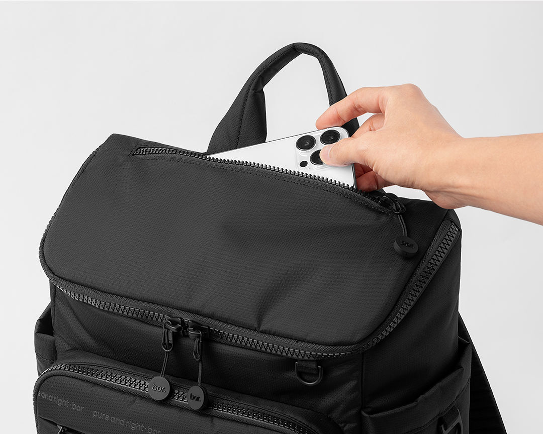 상단 지퍼 포켓에서 휴대폰을 바로 꺼낼 수 있는 bor 미니 백팩 사용 장면