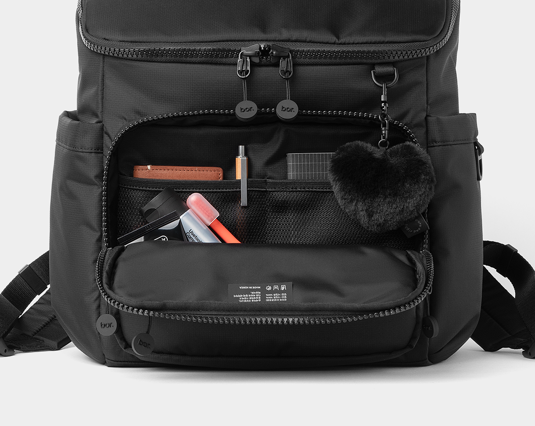 전면 지퍼 포켓을 열어 작은 소지품을 정리해 담은 bor 미니 백팩 모습