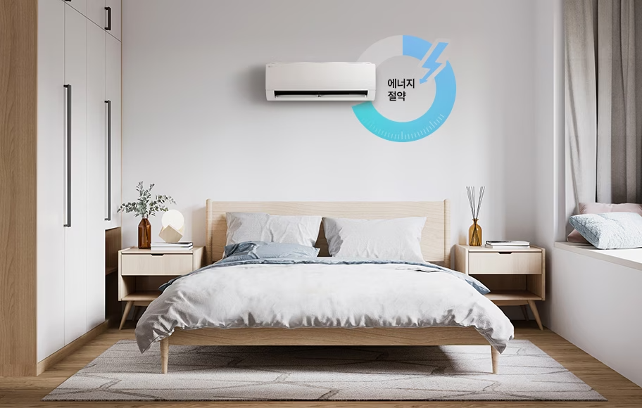 침대가 놓여있는 침실에 벽에 걸린 에어컨과 효율 운전 아이콘