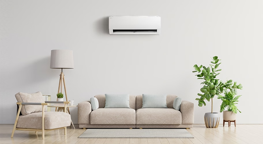 소파, 식물, 의자, 조명, 탁자가 있는 공간과 벽에 걸린 벽걸이 에어컨