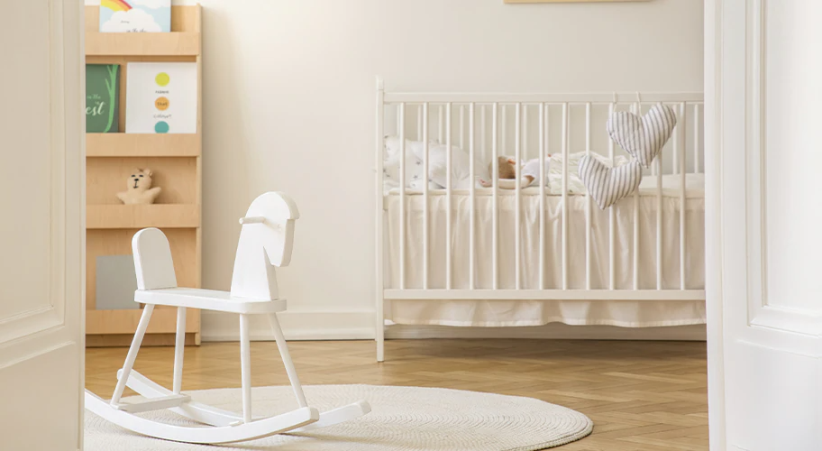 장난감 말, 책장이 있고 아기가 침대에 누워 있는 방