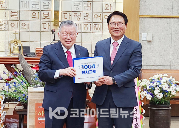 ▲지구촌사랑의쌀나눔재단 이사장 이선구 목사(왼쪽)가 안산3지부 박두환 지부장(오른쪽)에게 1004교회 현판을 전달하고 있다.