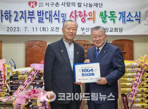 ▲(사)지구촌사랑의쌀나눔재단 이사장 이선구 목사(오른쪽)가 사하2지부 변정섭 지부장(왼쪽)에게 1004교회 현판을 전달하고 있다.