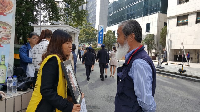 가습기살균제 사망자가 1000명을 넘었다. 가습기살균제로 아내를 잃은 피해자가족 최주완씨가 1인시위를 진행하고 있는 김미란씨에게 미안함과 안타까운 마음으로 위로와 격려를 보내고 있다. ⓒ환경운동연합