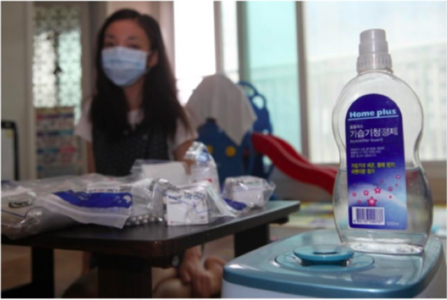 가습기살균제 피해로 폐이식을 해야했던 피해자가 폐이식 후에 복용해야 하는 약봉투와 홈플러스 가습기살균제 제품을 보여주고 있다 (출처 환경보건시민센터)