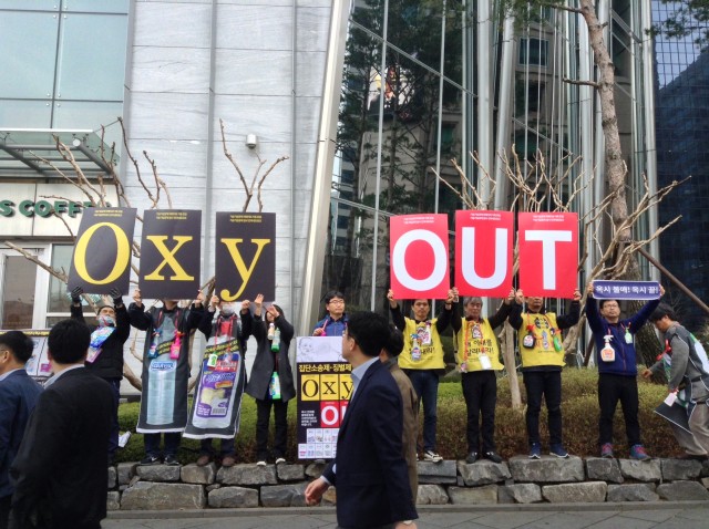 옥시 본사 앞에서 '옥시 아웃(OxyOUT)'이라고 쓰인 손팻말을 들고 캠페인을 진행하고 있다ⓒ가습기넷