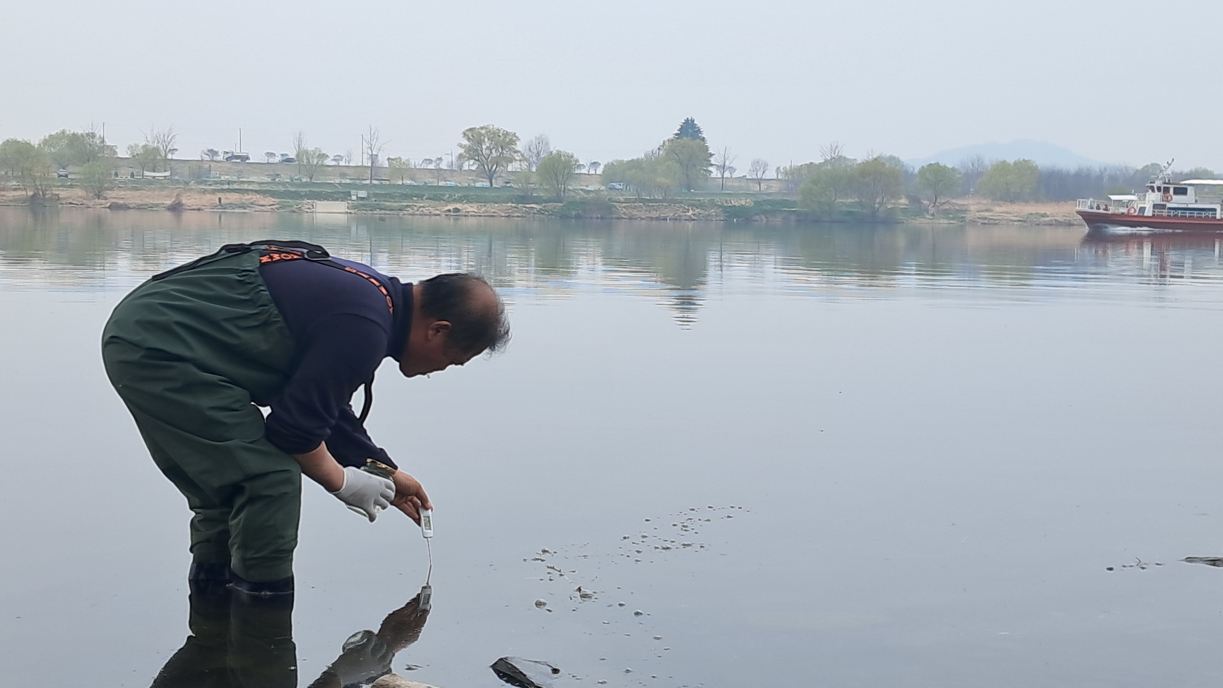 환경단체 시민조사단이 낙동강 화원유원지 일대에서 수온을 측정하고 수질 분석을 위한 채수를 진행하고 있다  사진제공 : 낙동강네트워크