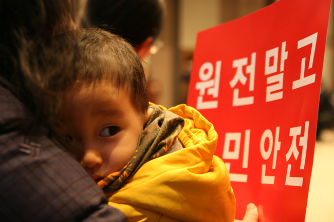 9일 서울 종로구 프레스센터 20층 국제회의장에서 월성1호기의 수명연장을 반대하는 국민선언이 열린 가운데 엄마를 끌어안고 있는 아이의 뒷편으로 원전말고 국민안전이 적힌 손팻말이 보인다.ⓒ정대희