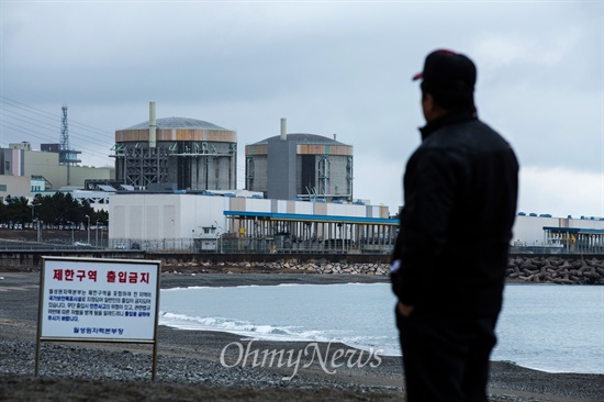 월성원전과 맞붙어 있는 나아리에 거주하는 한 주민이 3일 오후 경북 경주에 위치한 한국수력원자력 월성원자력본부의 (오른쪽부터) 월성1,2호기를 바라보고 있다. 월성1호기는 최근 원자력안전위원회에서 수명연장결정을 해 2022년까지 운행하게 된다. ⓒ 이희훈