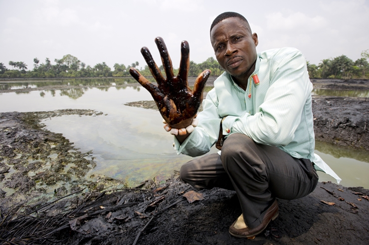 Eric-in-goi-village-showing-oilpollution.jpg