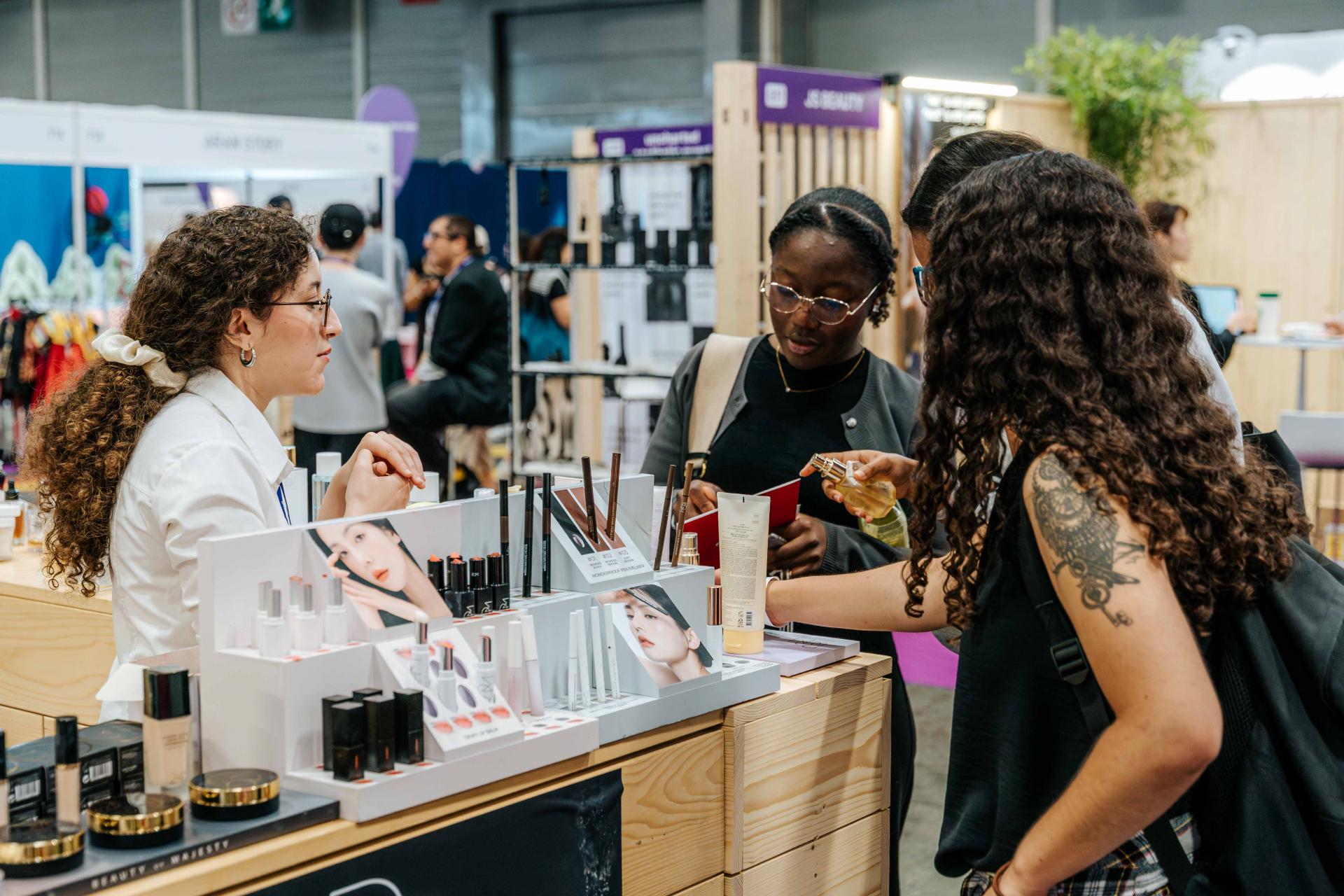Korea Expo K-Beauty booth—exhibitor demonstrating makeup products to visitors