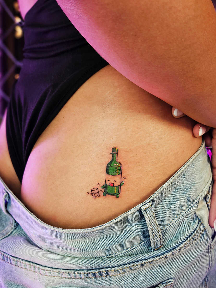 Tattoo artist working on a soju design in Hongdae