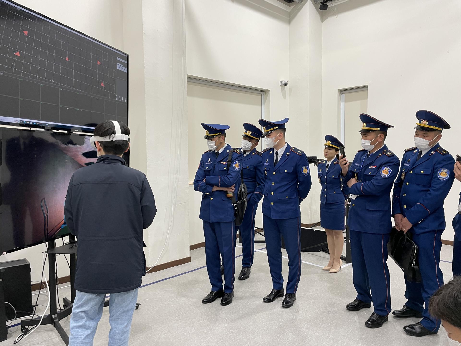 Uniformed visitors observing a VR training demonstration
