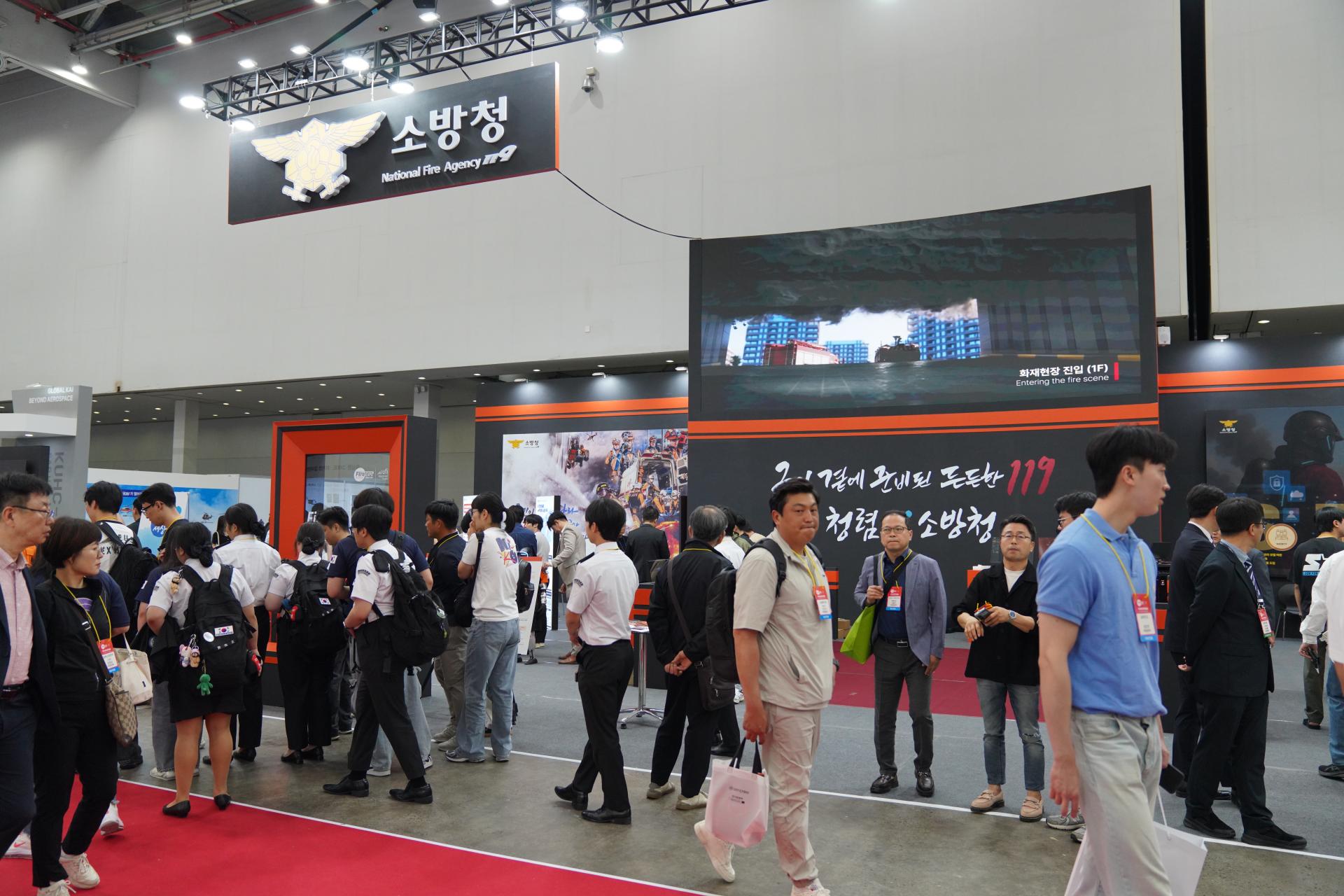 Visitors exploring the National Fire Agency exhibition booth and firefighting training displays