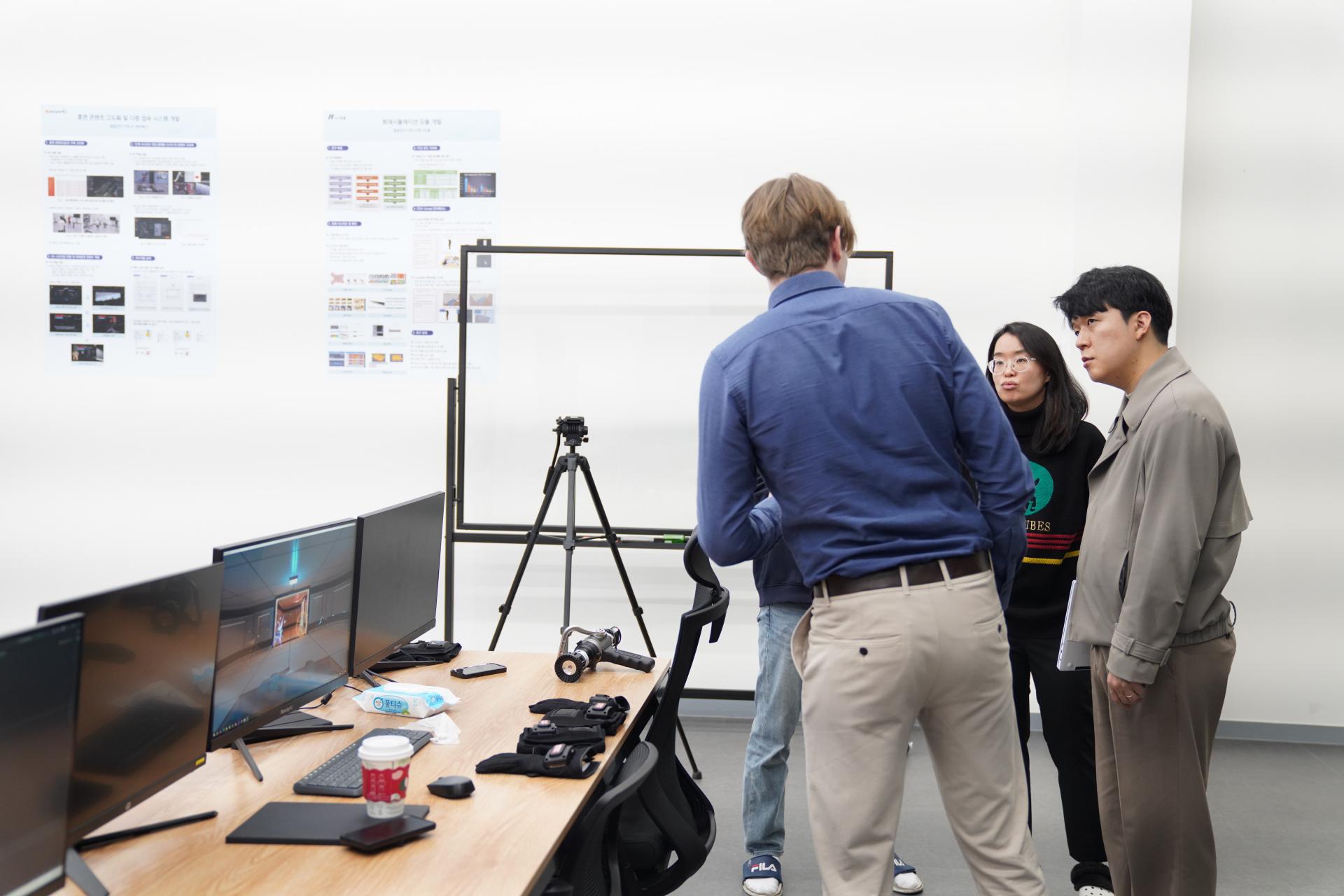 Visitors discussing motion capture equipment at iPOP's research workspace