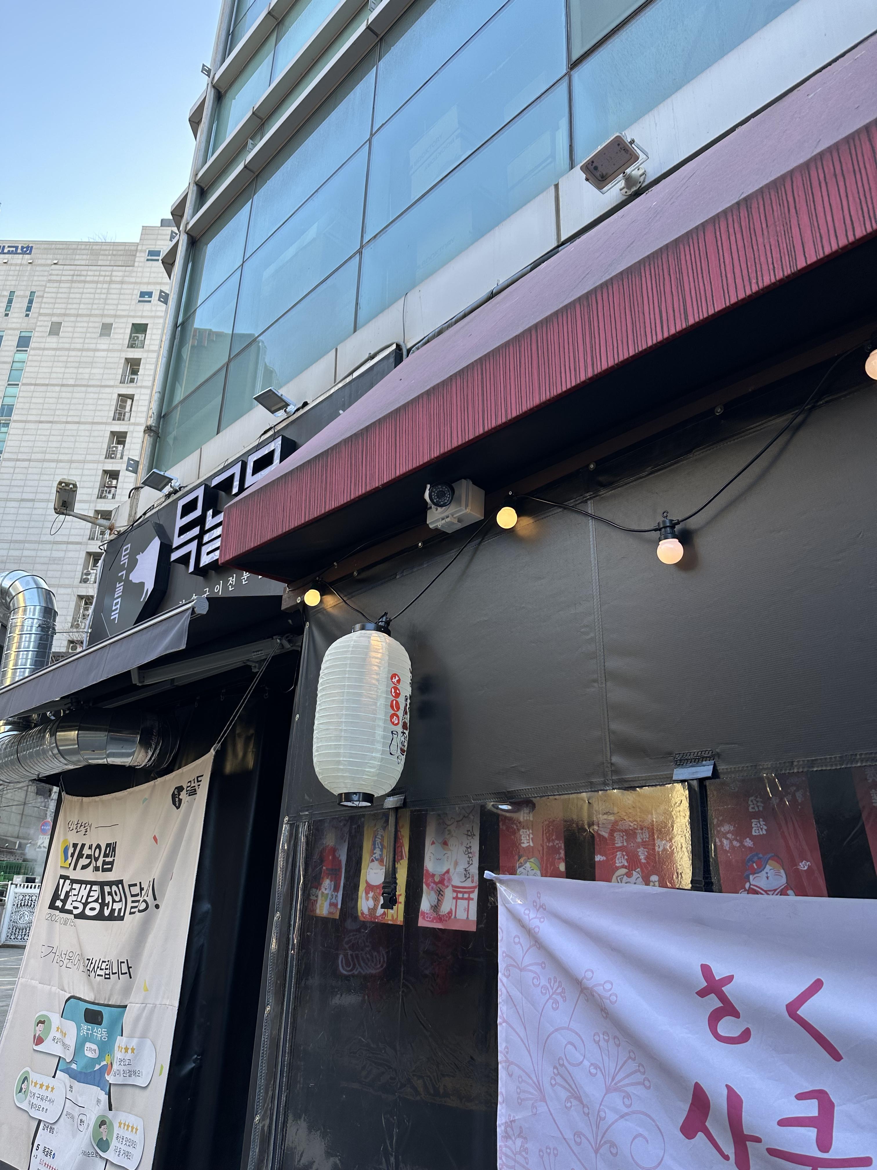 이자카야 외부 천장에 설치된 아날로그 CCTV, 간판과 전등 아래 위치
