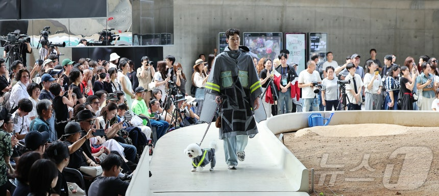 14일 서울 중구 동대문디자인플라자(DDP)에서 열린 반려견과 함께하는 제로웨이스트 패션쇼 '댕댕 런웨이’에 참가한 모델들과 반려견들이 무대 위로 워킹하고 있다. 2025.9.14/뉴스1 ⓒ News1 김진환 기자