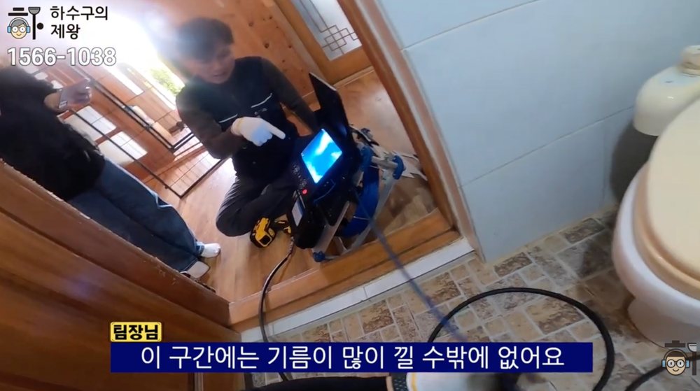 작업자가 내시경 화면을 보며 전원주택 하수 배관의 처진 구간과 기름 막힘 원인을 설명하는 장면