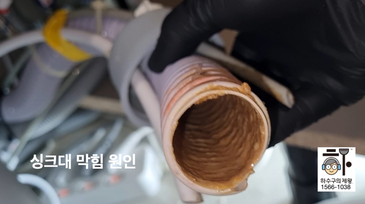 마포구 중동 아파트 싱크대 연결 호스 내부에 기름때가 코팅처럼 붙어 있는 상태를 하수구의제왕이 확인한 장면
