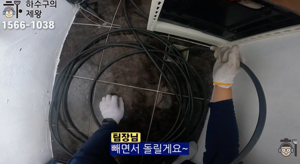 광명시 광명동 빌라 하수구 막힘 해결을 위해 플렉스샤프트 장비를 배관에 투입하는 장면