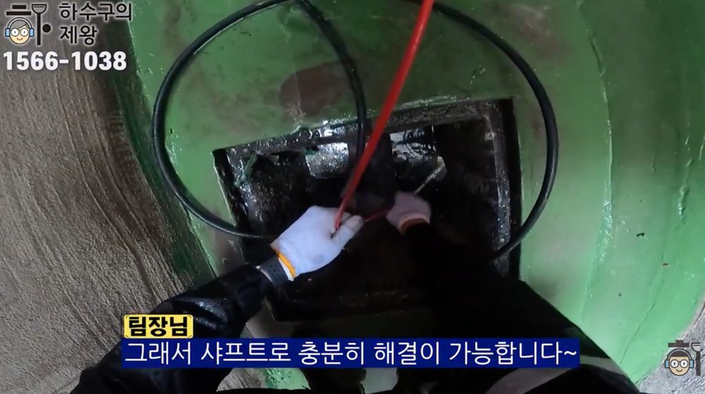 광진구 군자동 카페 하수구 막힘 해결을 위해 집수정 내부로 샤프트 장비를 투입해 배관 내 기름 슬러지와 이물질을 제거하는 작업 모습
