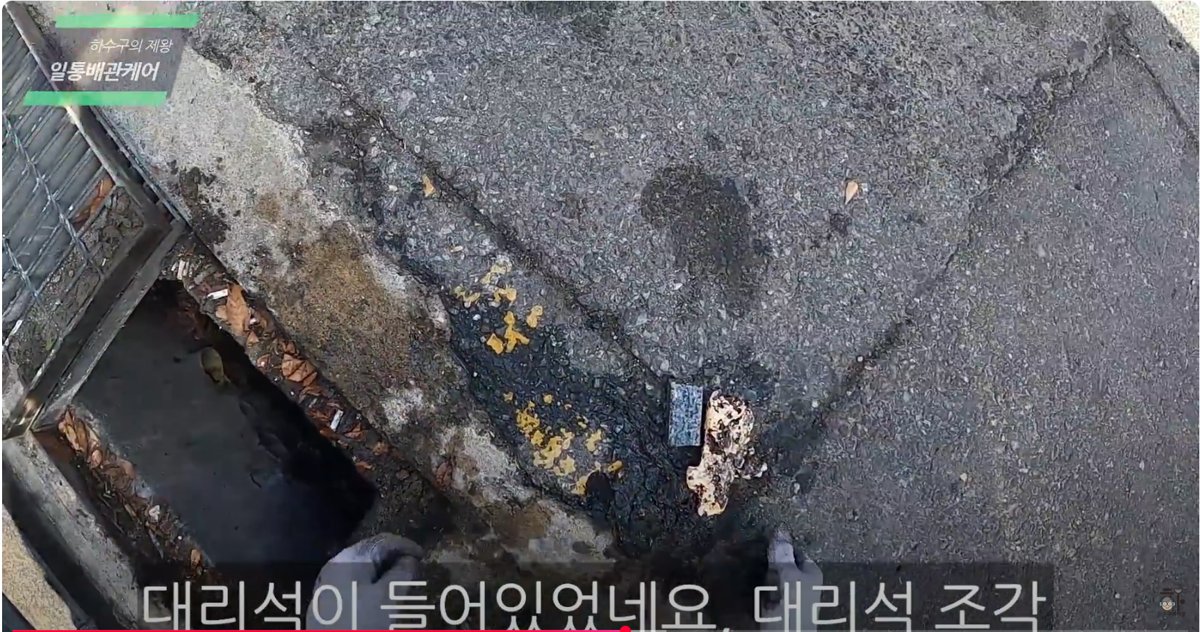 남양주 주택 외부의 맨홀을 개방하여 하수구 내부를 점검하는 장면입니다. 대리석 조각과 낙엽, 기름때가 섞여 하수 흐름을 방해하고 있었으며, 외부 유입 이물질로 인한 막힘 문제 해결이 필요한 상황이었습니다