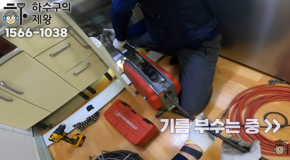 도봉구 쌍문동 다세대주택 주방 하수구 막힘을 해결하기 위해 배관 청소 장비를 투입하는 작업 모습