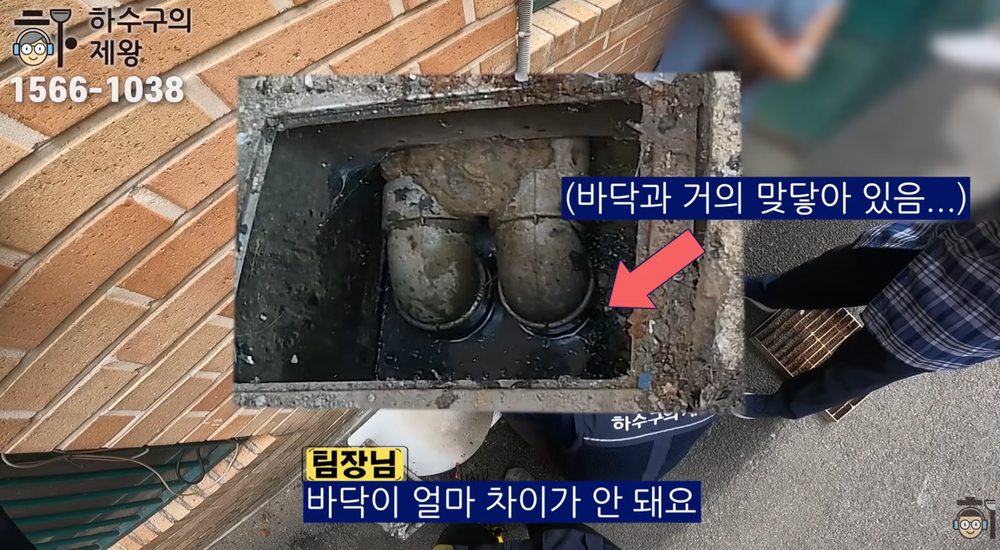 성남시 단대동 빌라 외부 집수정에서 배관 끝부분과 바닥 간격이 좁은 구조를 설명하는 장면