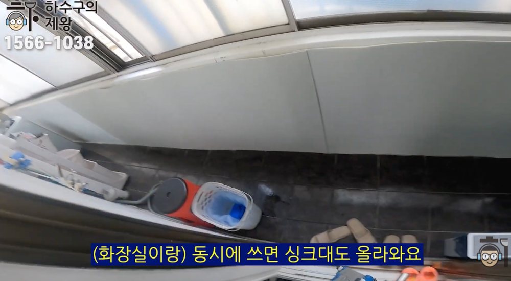 광명시 광명동 빌라 베란다 하수구에서 물이 역류하는 증상을 확인하는 현장 장면