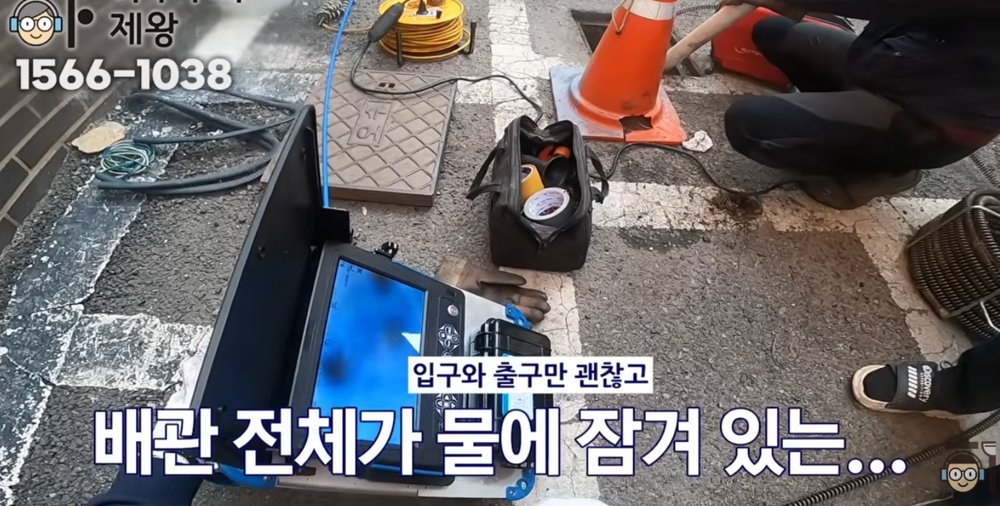 부천시 빌라 외부 하수관이 중간 구간에서 가라앉아 물이 고이는 역구배 구조를 설명하는 현장 장면