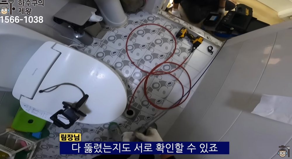 구리시 수택동 빌라 화장실 배수구에 배관 장비를 투입해 역류 원인을 점검하는 작업 모습