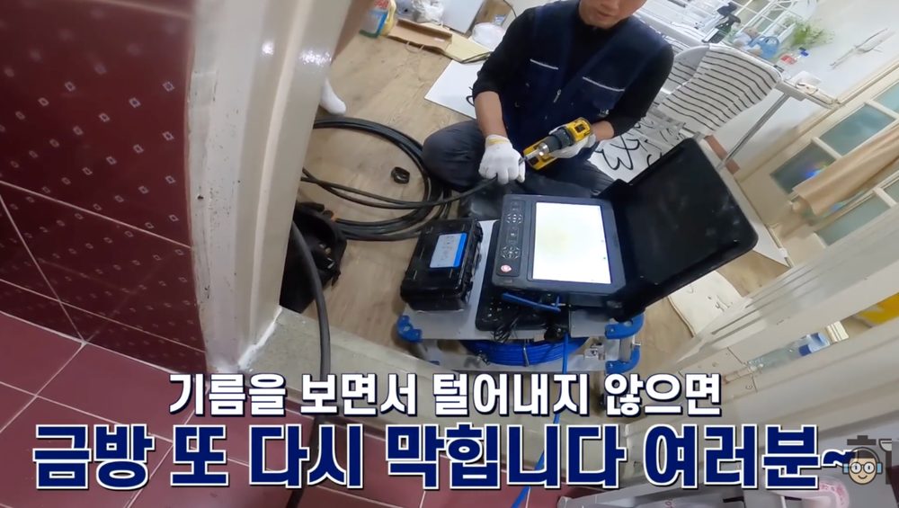 작업자가 내시경 장비와 케이블을 준비해 하수구 안으로 장비를 넣기 전 점검하는 모습
