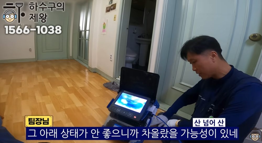 도봉구 쌍문동 다세대주택 하수구 막힘의 원인이 기름 슬러지 축적임을 내시경 영상으로 설명하는 모습
