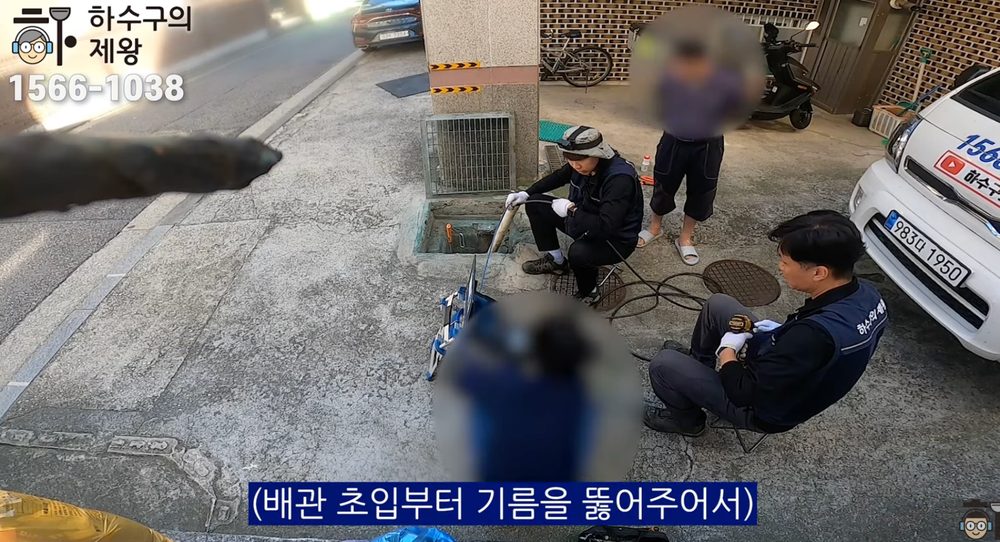 광진구 구의동 빌라 외부 점검구에서 배관 장비를 투입해 기름 막힘 구간을 확인하고 작업하는 현장 이미지