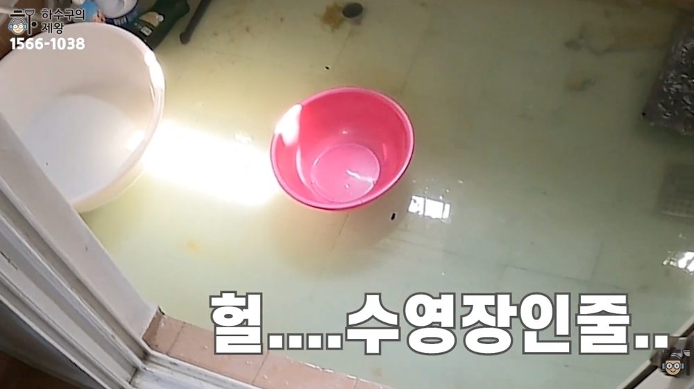 반지하 빌라 화장실 바닥에 오수가 역류해 물이 차오른 모습으로, 문턱 앞까지 물이 고여 있는 초기 침수 현장 사진