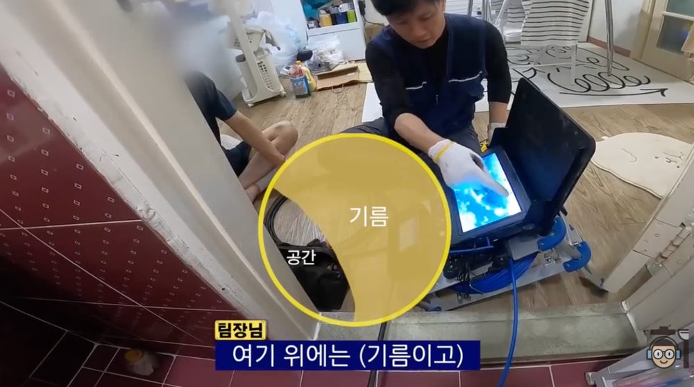작업자가 내시경 장비 화면을 보며 배관 안쪽의 기름이 쌓인 상태를 설명하는 장면