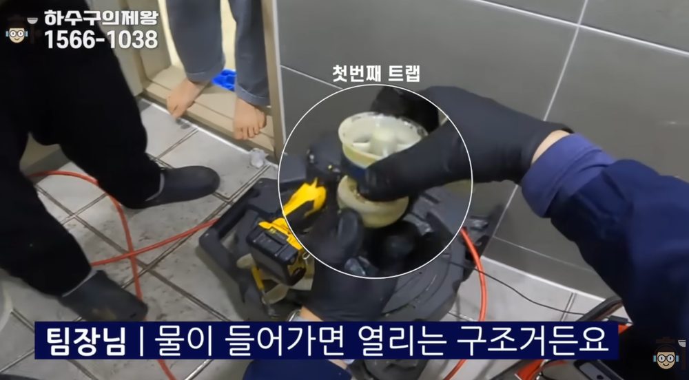강서구 화곡동 빌라 하수구 역류 현장에서 배관 속에 빠진 첫 번째 플라스틱 트랩을 회수하는 장면
