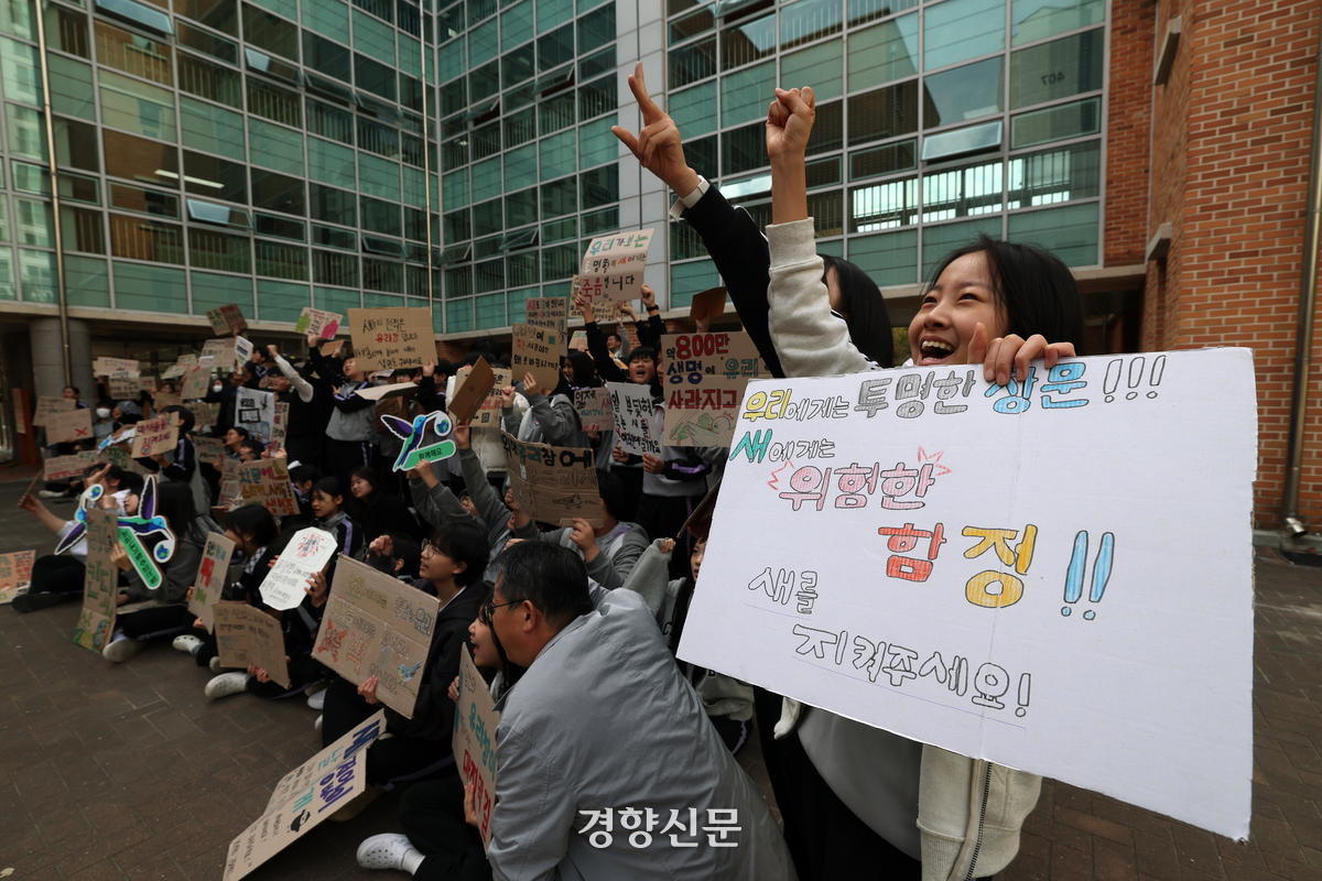경기 광명시 충현중학교 1학년 학생들이 충현중학교 유리창에 조류 충돌방지 스티커를 부착하는 ‘새유리 대작전’활동 후 조류 보호를 촉구하는 손팻말을 들고 있다. 권도현 기자
