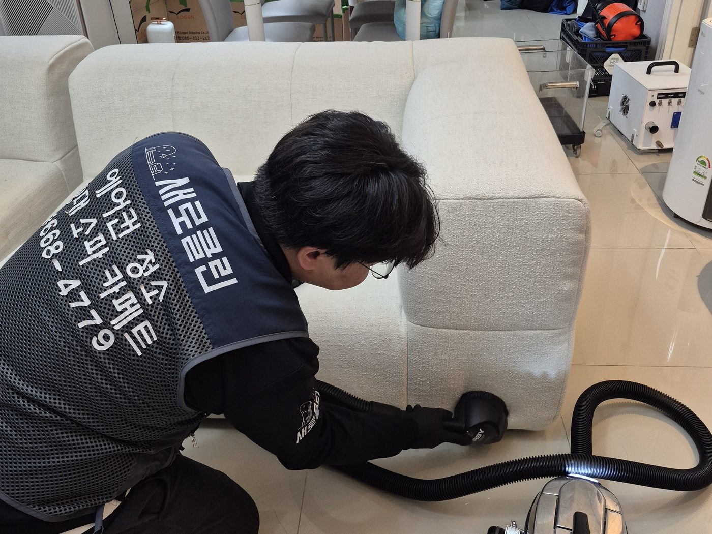 물을 대기 전 집진 장비로 소파 아래 바닥까지 훑는 중