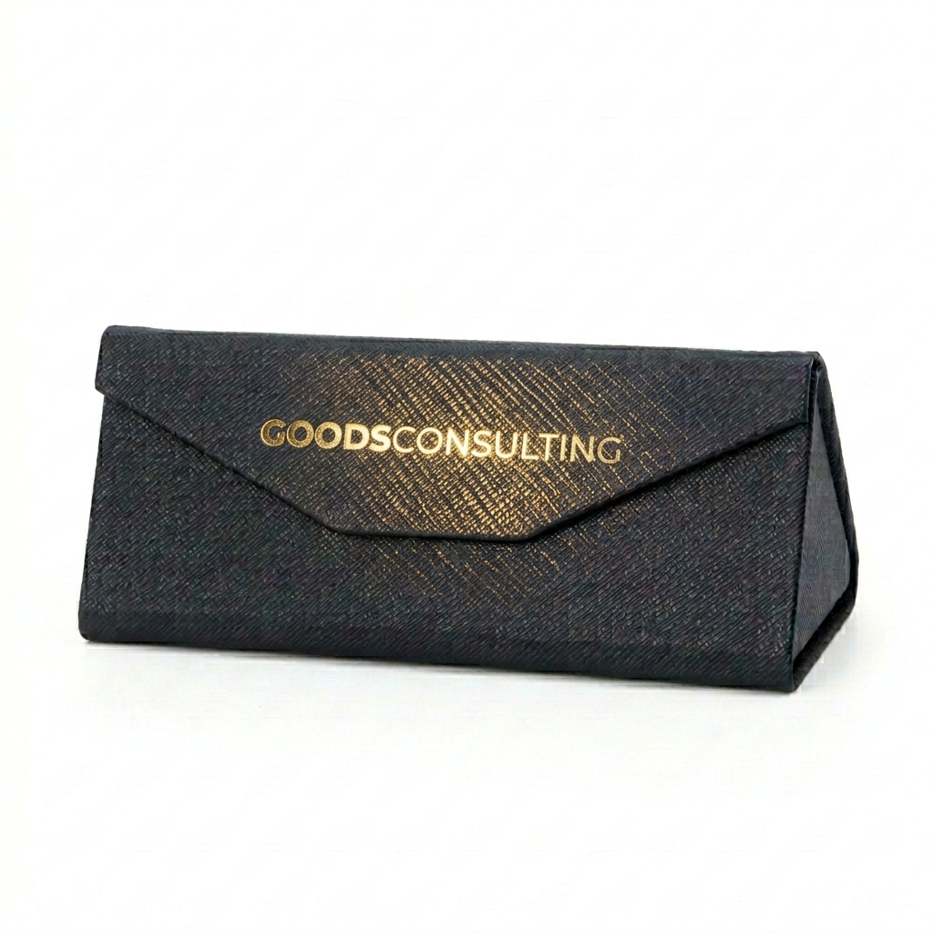 블랙 가죽 위에 화려하고 중후한 금박으로 인쇄된 GOODS CONSULTING 로고